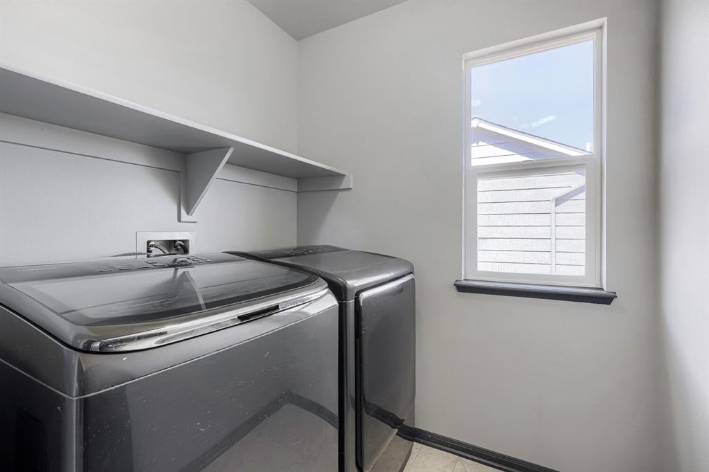 Image 22 of 27: Dedicated laundry area featuring a single window, built-in shelving, and ut