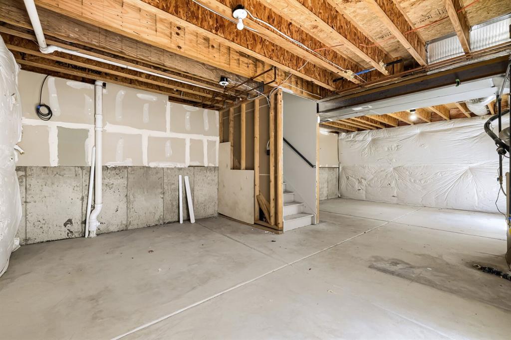 Image 23 of 27: Unfinished basement featuring concrete flooring, exposed wood joists, parti