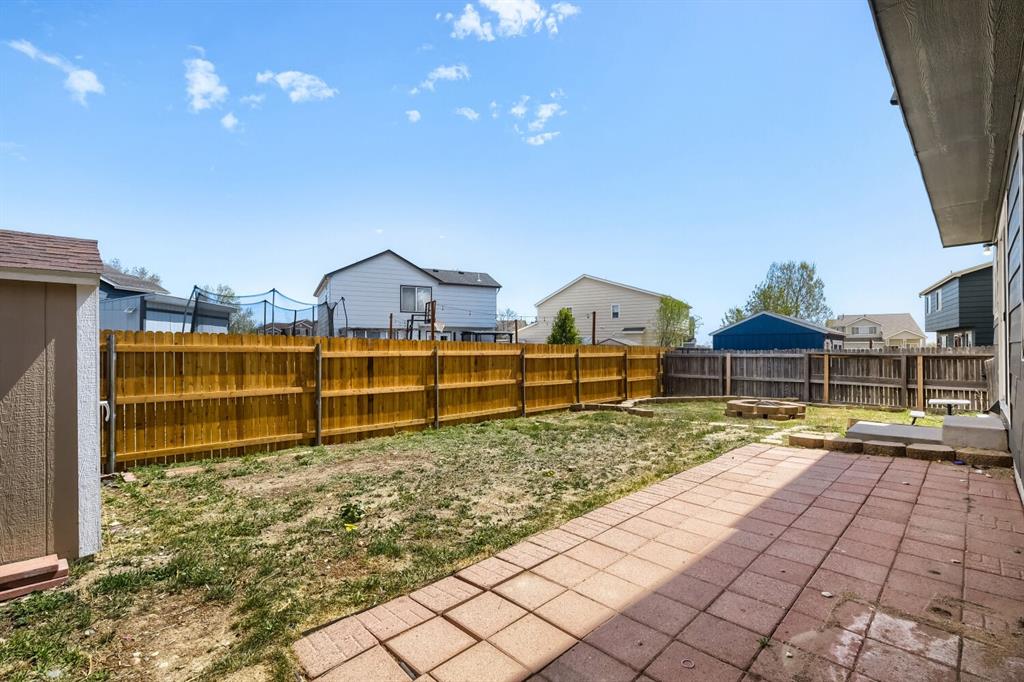 Image 24 of 27: Expansive backyard featuring a paver patio and a wood privacy fence