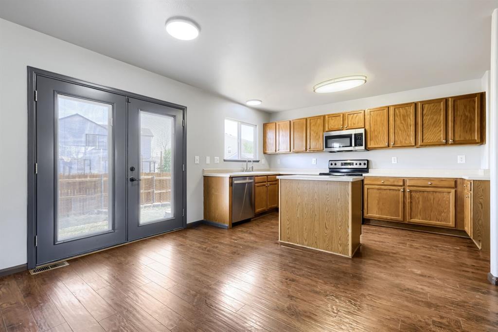 Image 6 of 27: Kitchen featuring wood-finish flooring, a central island, light wood cabine