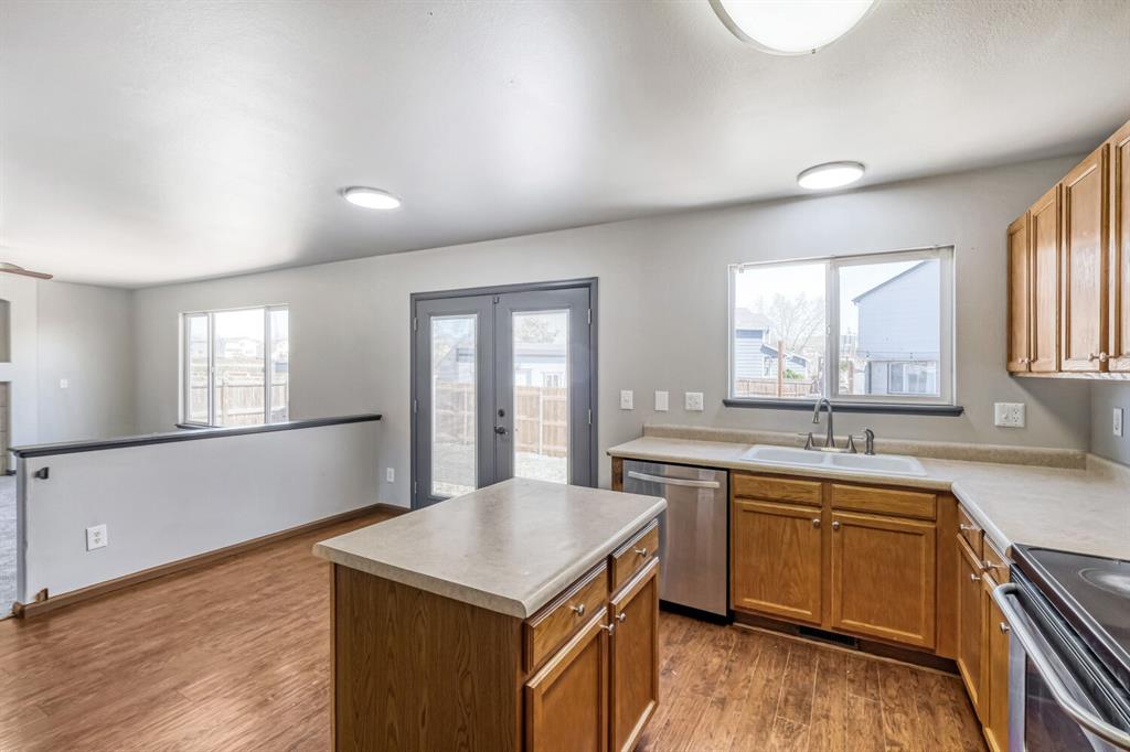 Image 9 of 27: Kitchen featuring wood-finish flooring, a central island with countertop, a