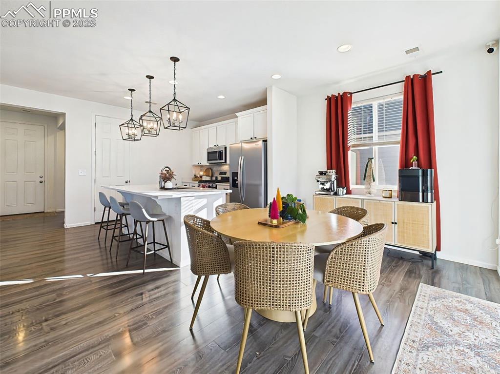 Image 11 of 50: A full view of the open-plan kitchen and dining areas, where large windows,
