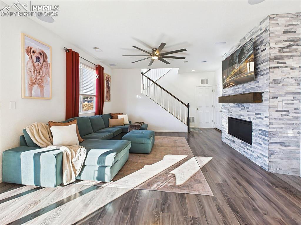 Image 20 of 50: Bright and spacious living area anchored by a stacked stone fireplace with 