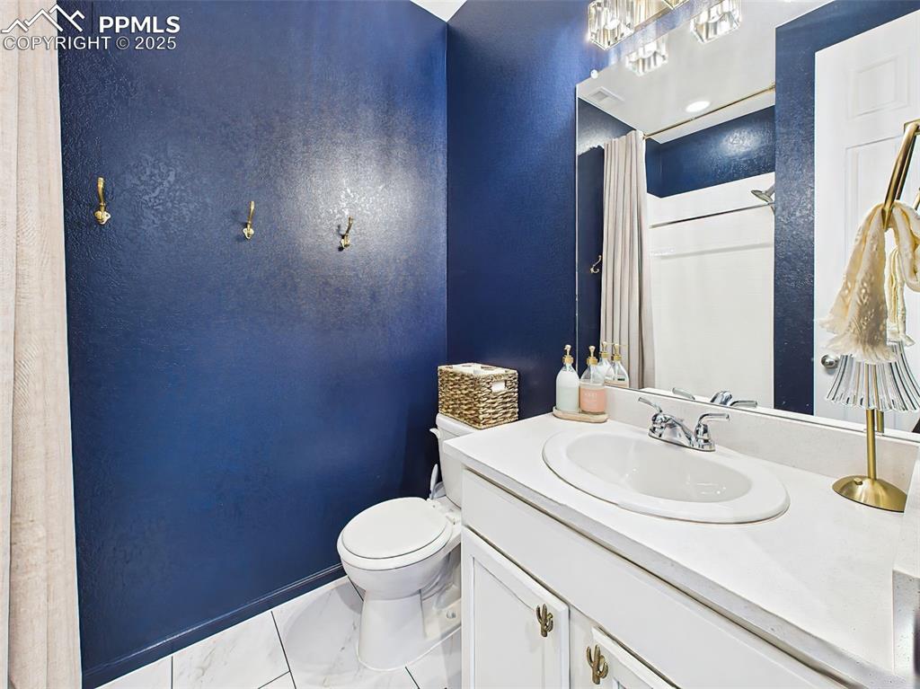 Image 24 of 50: 3/4 bathroom on the main level features chrome fixtures, white tile shower,