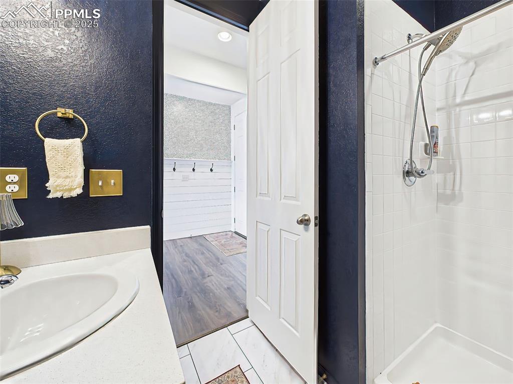 Image 25 of 50: Vanity View – Fresh and functional full bath with rich navy accent walls, q