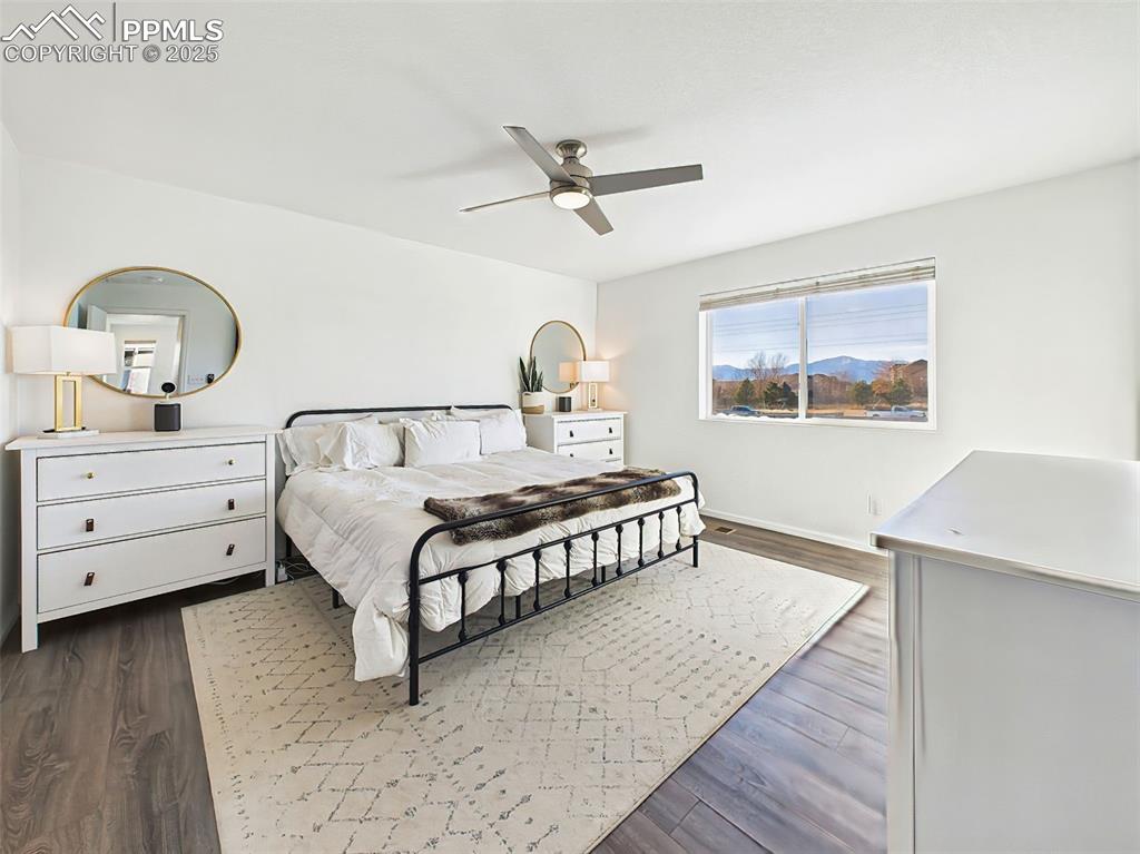 Image 27 of 50: Expansive primary suite with ceiling fan, stunning Pikes Peak views, and st