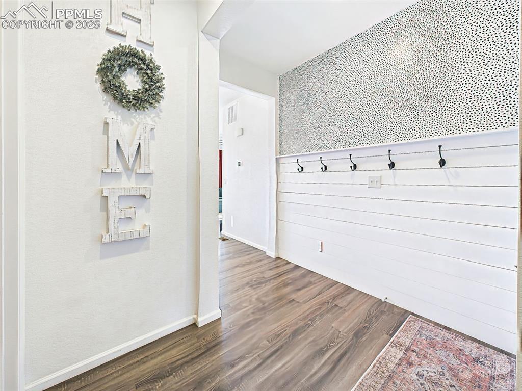 Image 3 of 50: Functional and stylish entry space with a coat closet, decorative wall hook