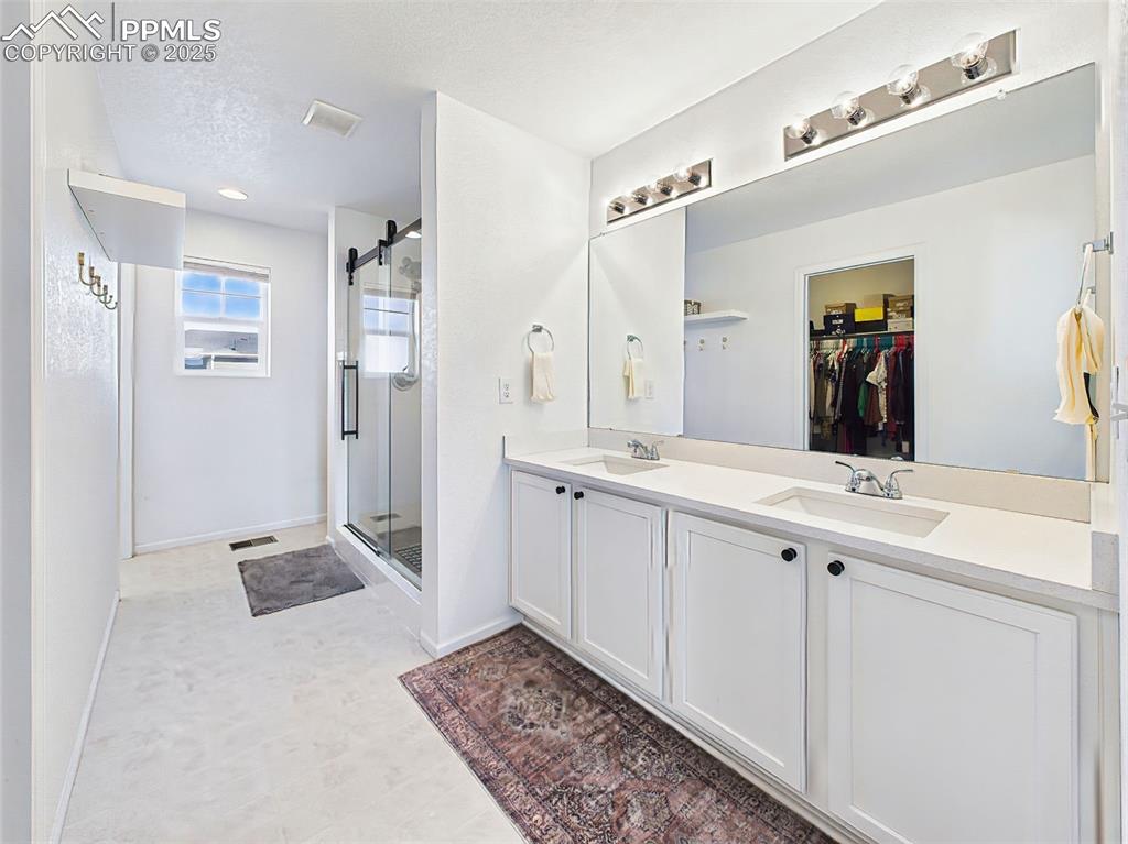 Image 30 of 50: Spa-inspired primary bathroom with quartz countertops, dual sinks, upgraded