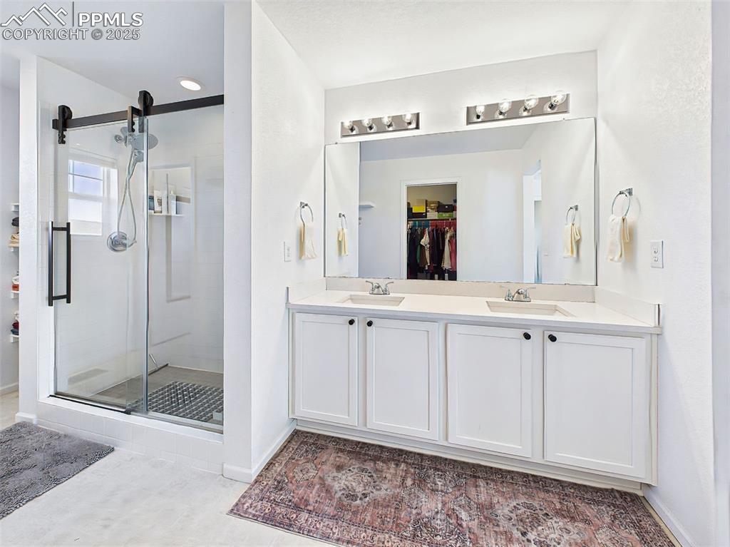 Image 31 of 50: Spacious and bright, the primary ensuite bathroom features dual sinks, whit