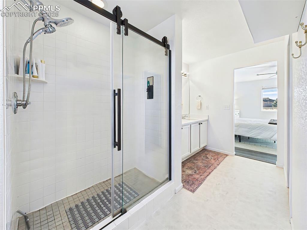 Image 32 of 50: The oversized walk-in shower boasts a seamless glass enclosure with matte b