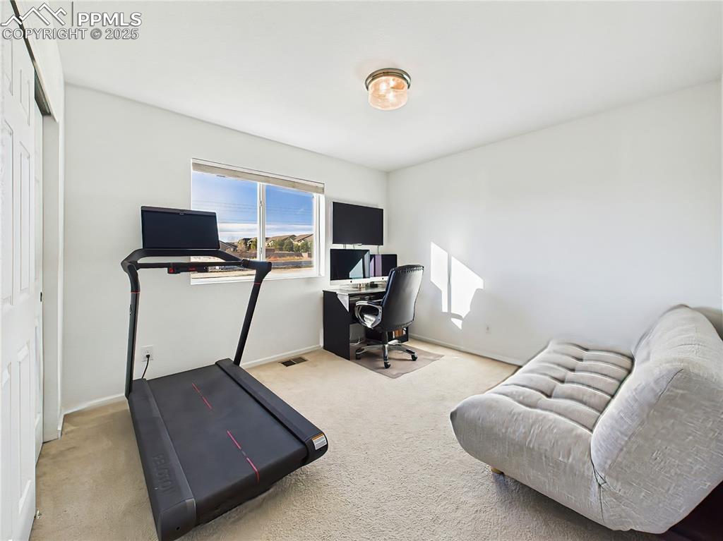 Image 35 of 50: Sun-filled secondary bedroom with a large window, ample closet space, and f