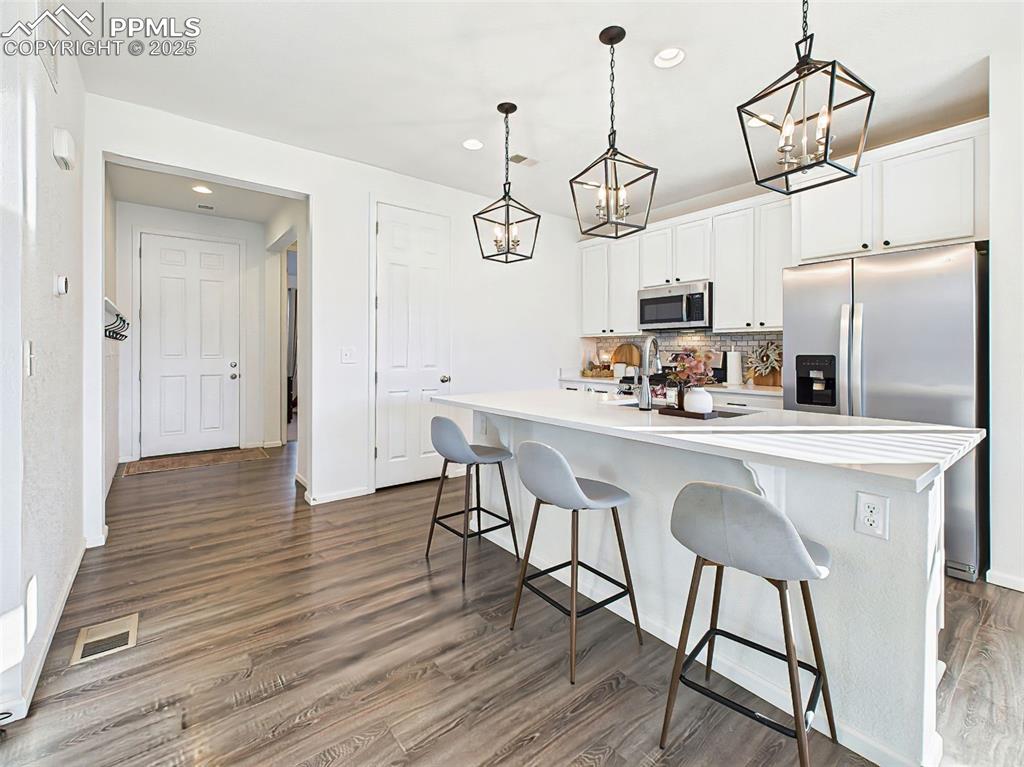 Image 4 of 50: View from the kitchen toward the main entry shows luxury vinyl plank floori