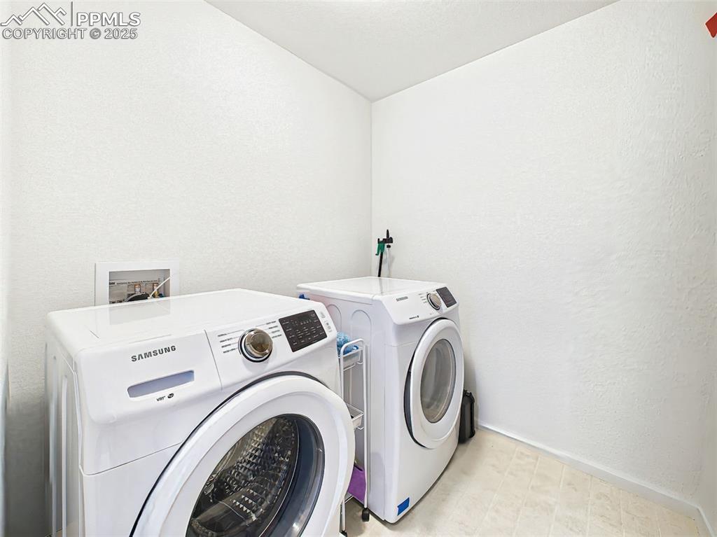 Image 40 of 50: Dedicated laundry room features Samsung front-load washer and dryer with ro