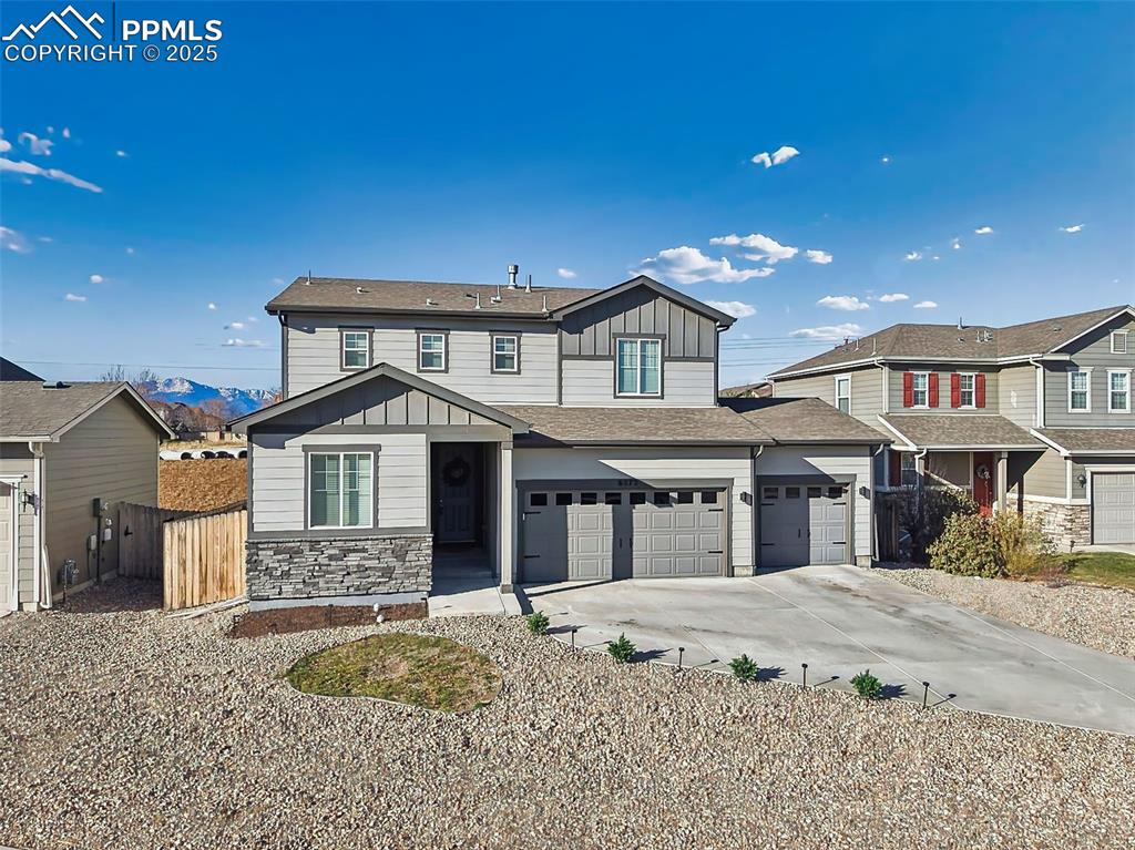 Image 42 of 50: Welcoming curb appeal with upgraded garage lighting, covered entry, and tho