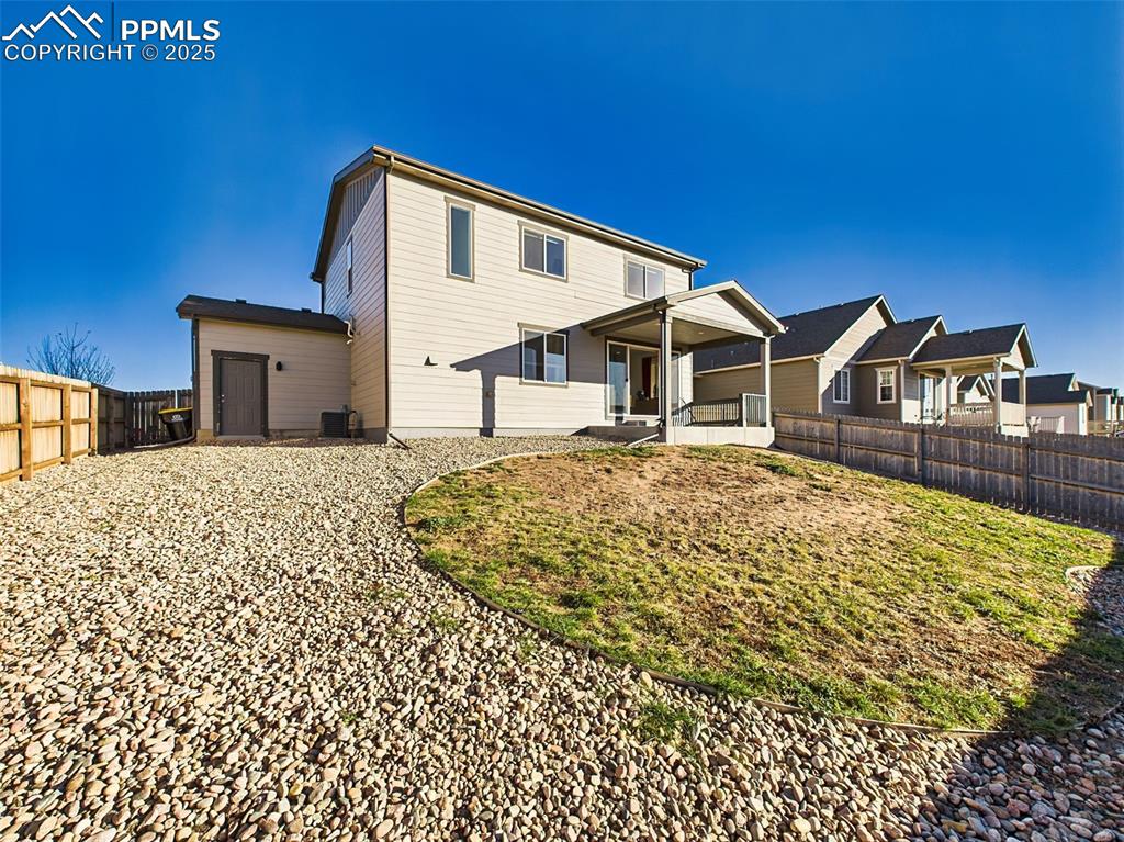 Image 47 of 50: Back of the home features dual windows, a central slider, and walk-out acce