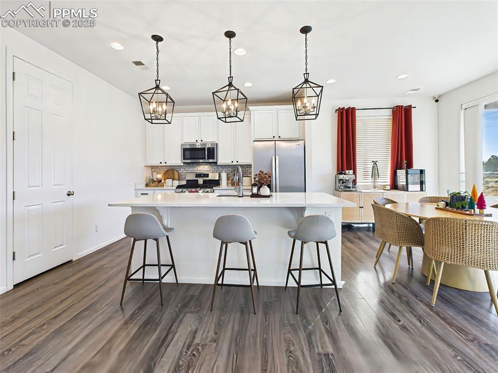 Image 5 of 50: Light-filled dining nook sits just off the kitchen, surrounded by full-heig