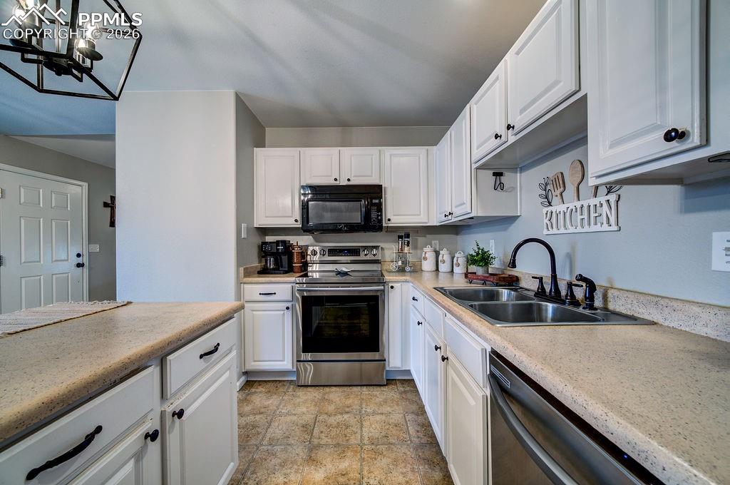 Image 18 of 48: Abundant white cabinets for kitchen storage.