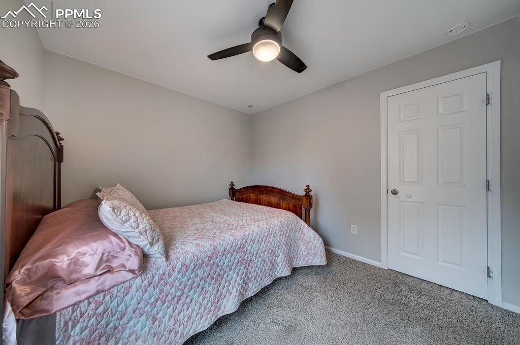Image 35 of 48: Bedroom #3 has neutral carpet, a lighted ceiling fan, and generous closet.