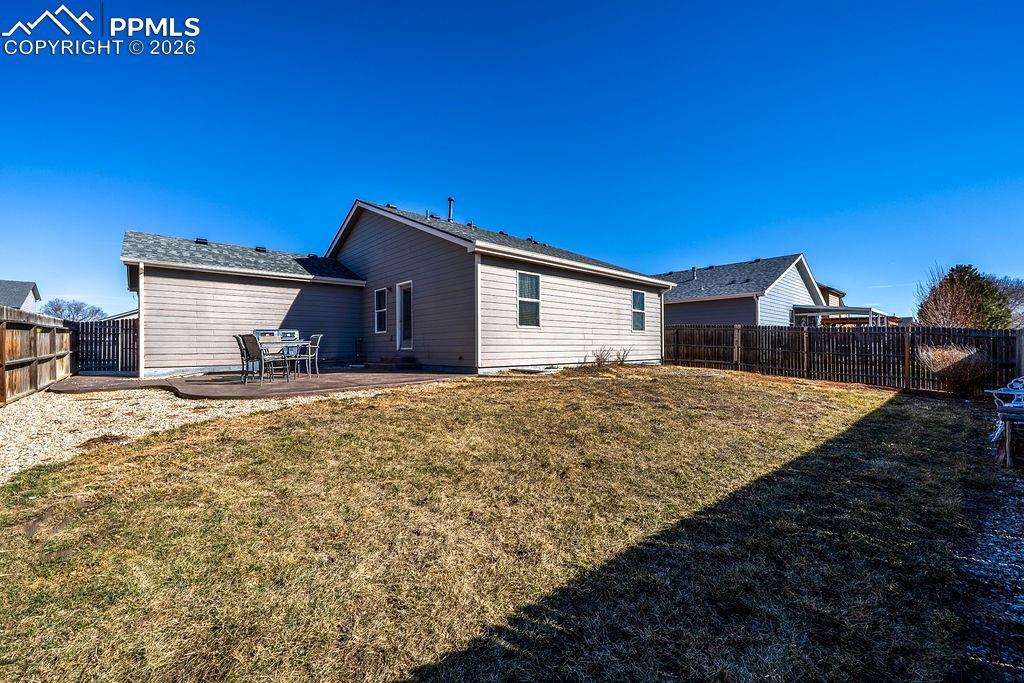 Image 45 of 48: Rear view of fenced backyard and patio.