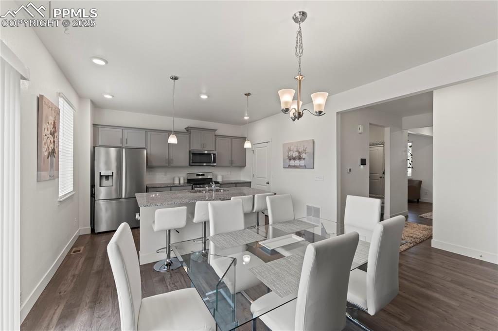 Image 10 of 39: Dining space featuring dark wood-style flooring, recessed lighting, and a c