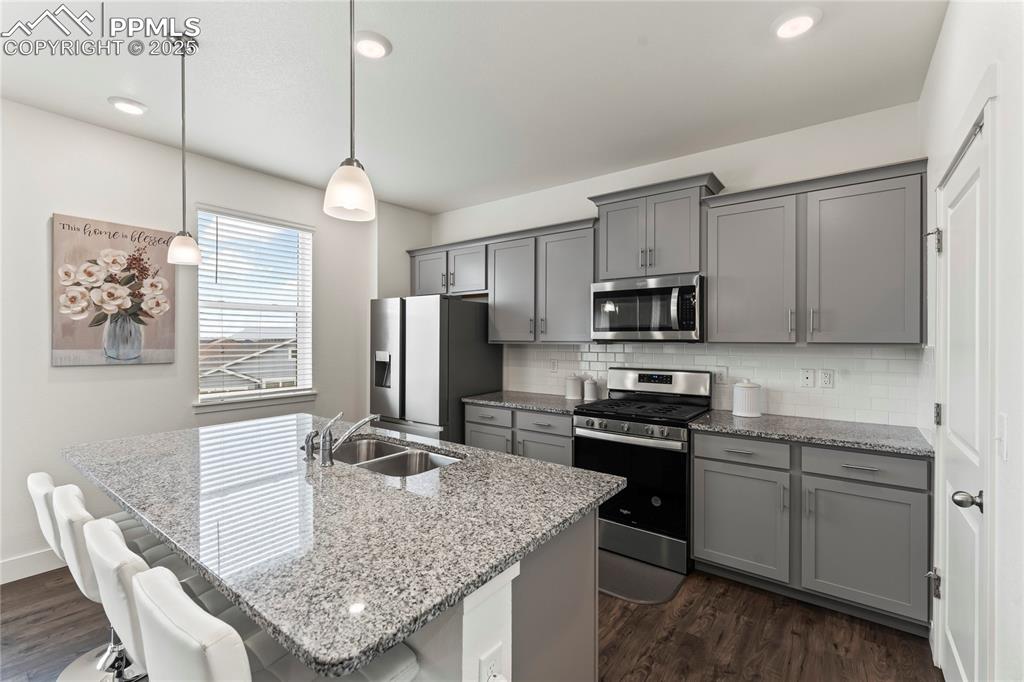 Image 11 of 39: Kitchen featuring gray cabinets, appliances with stainless steel finishes, 