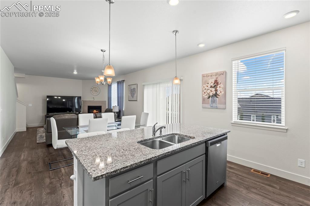 Image 12 of 39: Kitchen with gray cabinetry, light stone countertops, a kitchen island with