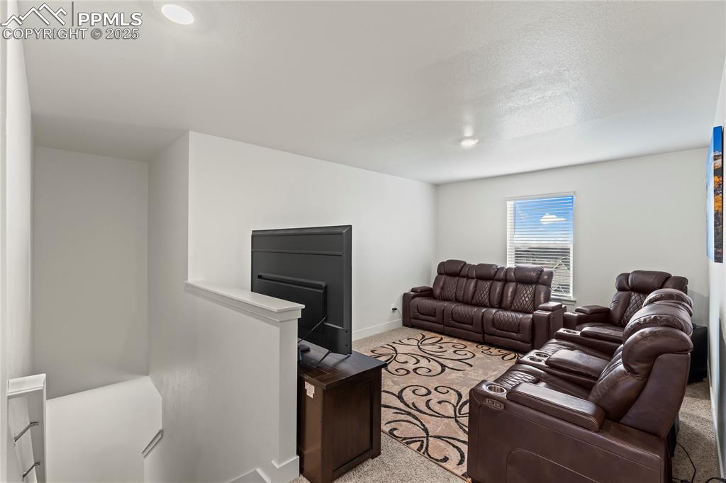 Image 18 of 39: Living area featuring carpet flooring and baseboards