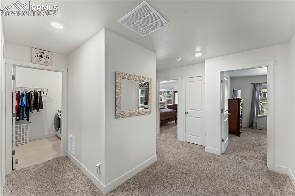 Image 20 of 39: Hall with light carpet, recessed lighting, washer / dryer, and healthy amou