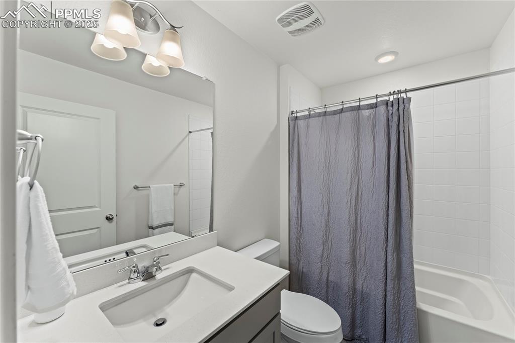 Image 24 of 39: Bathroom featuring shower / bath combo and vanity