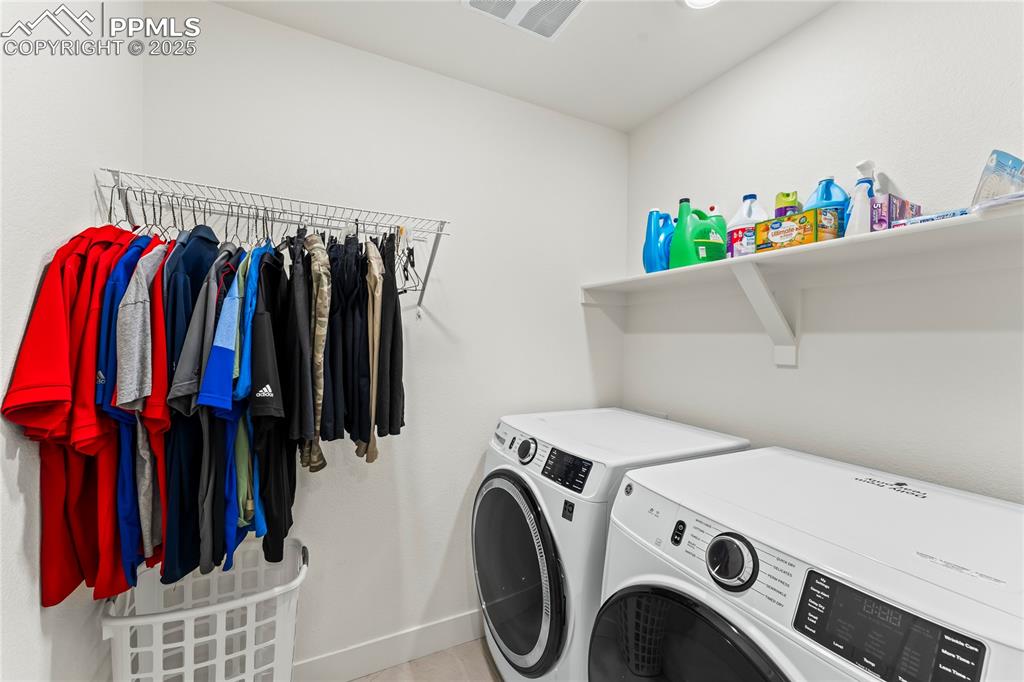 Image 32 of 39: Washroom with independent washer and dryer and baseboards