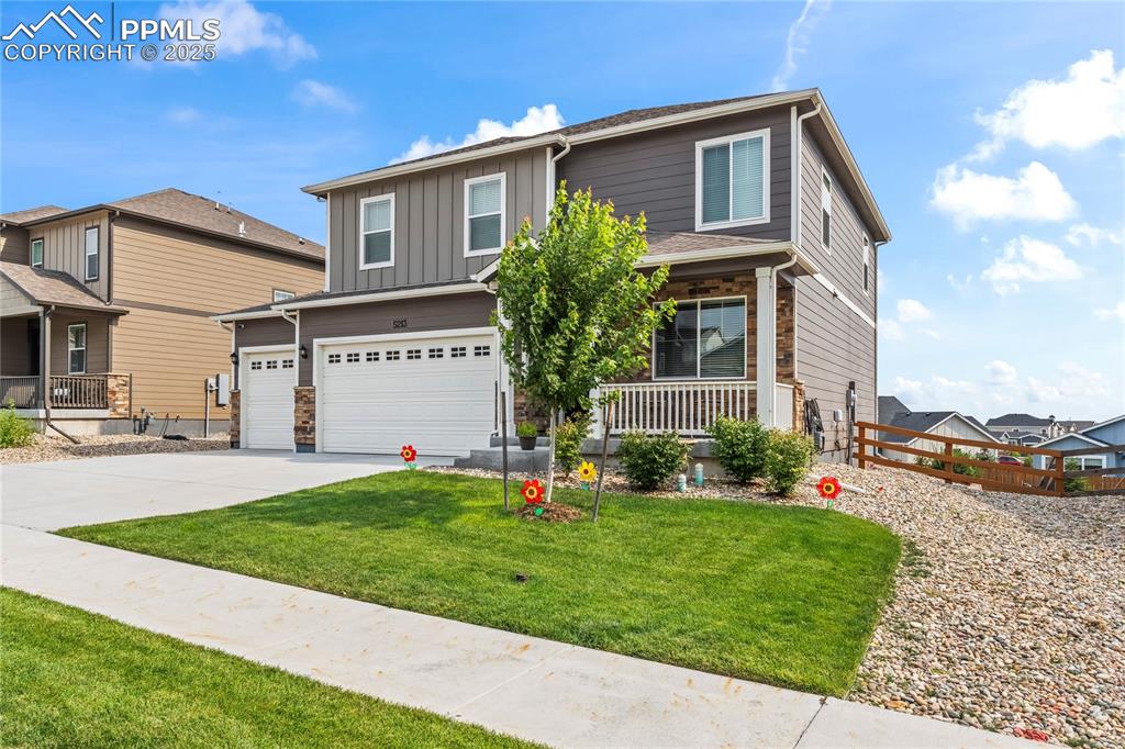 Image 39 of 39: View of front of home featuring a garage, driveway, a porch, and board and 