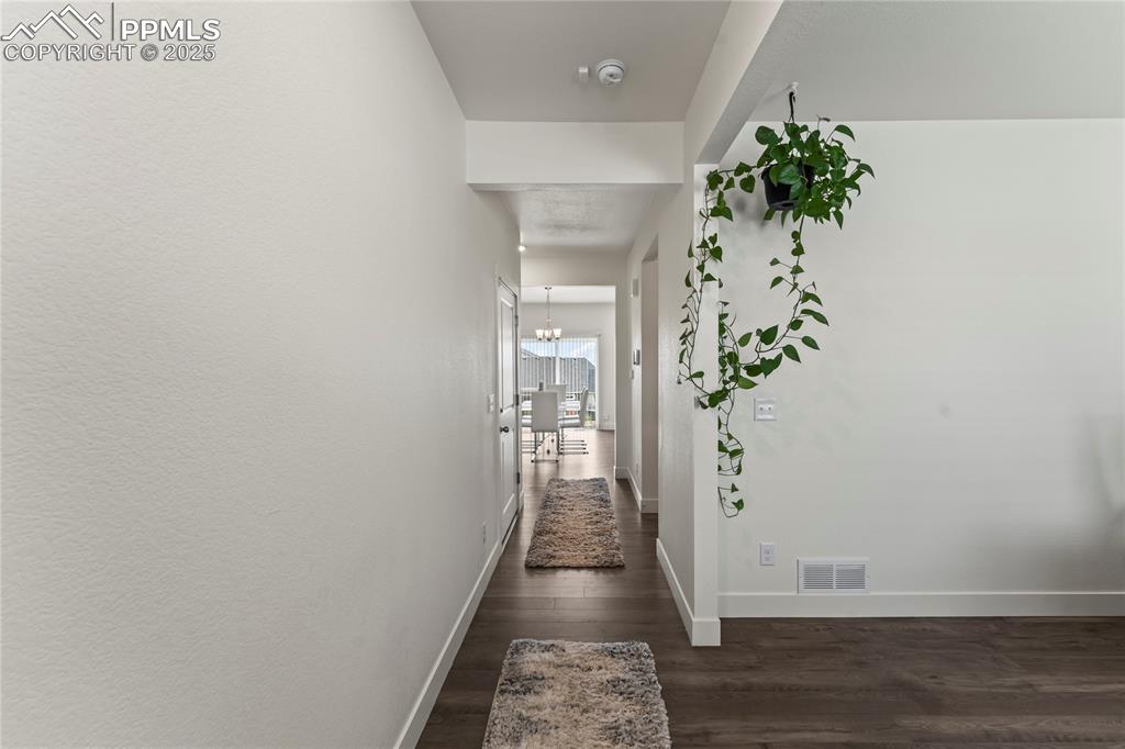 Image 4 of 39: Hall with dark wood-style floors and baseboards