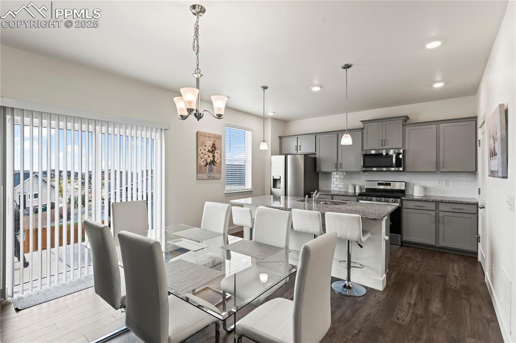 Image 9 of 39: Dining room featuring a chandelier, dark wood finished floors, and recessed