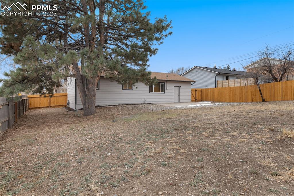 Image 36 of 36: Private backyard with mature tree.
