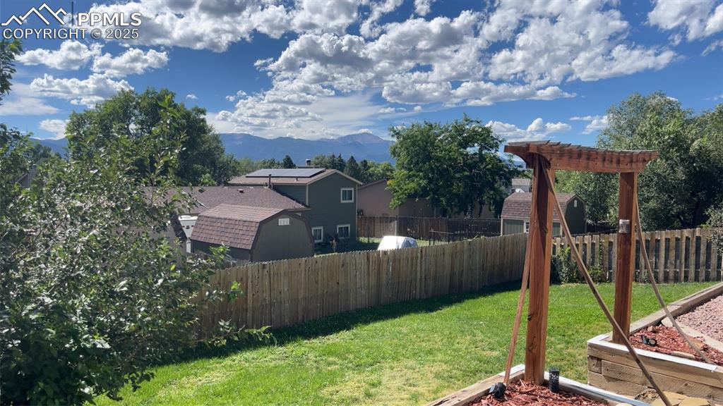 Image 33 of 38: Fenced backyard featuring a mountain view and a pergola