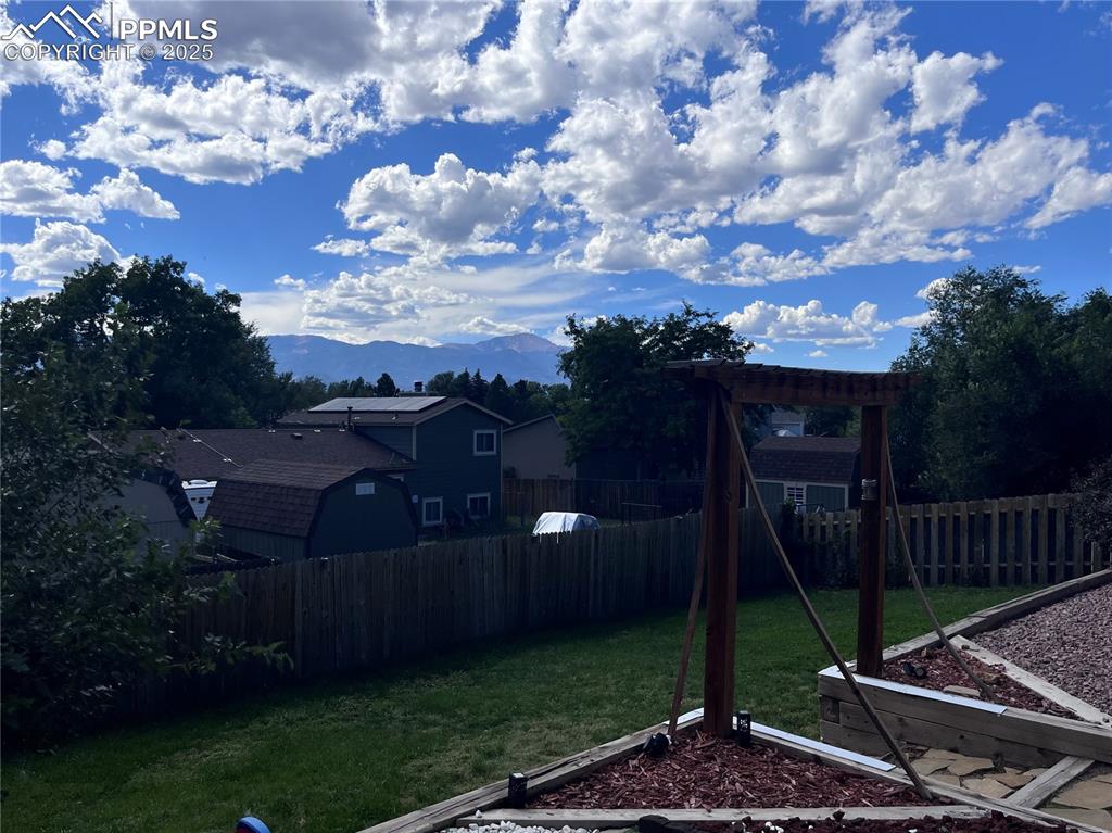 Image 34 of 38: Fenced backyard with a mountain view