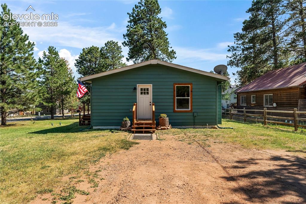 Image 10 of 32: Green siding exterior with white trim