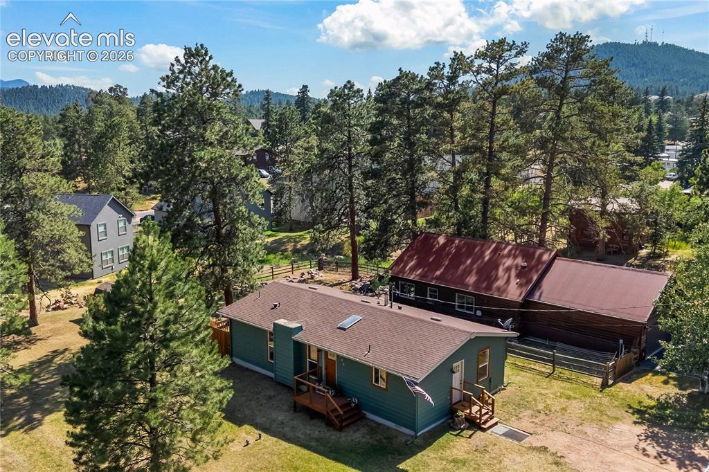 Image 2 of 32: Spacious property featuring a teal-sided main residence with an attached de