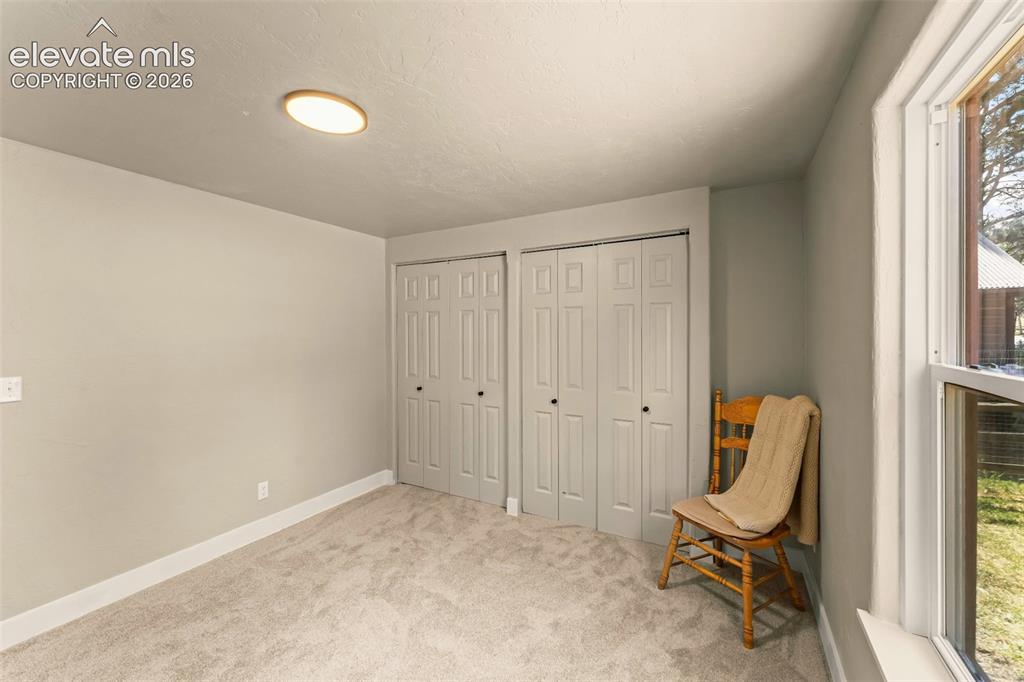Image 26 of 32: Room with light gray walls, gray carpet flooring, and a flush-mount ceiling