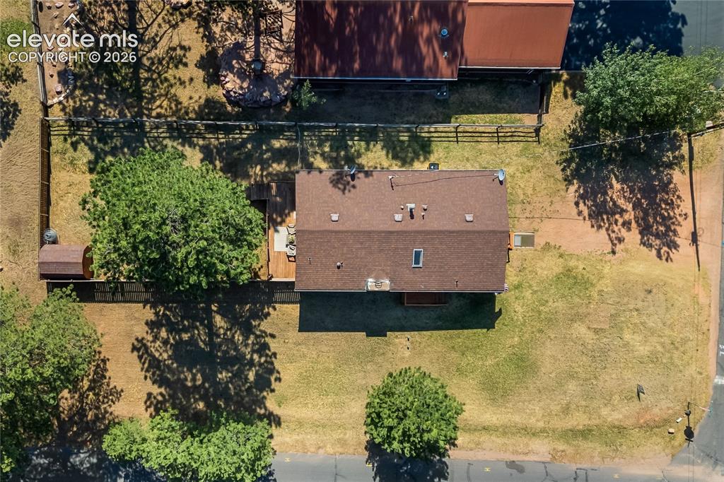 Image 3 of 32: Spacious property lot featuring a central structure with a brown shingle ro