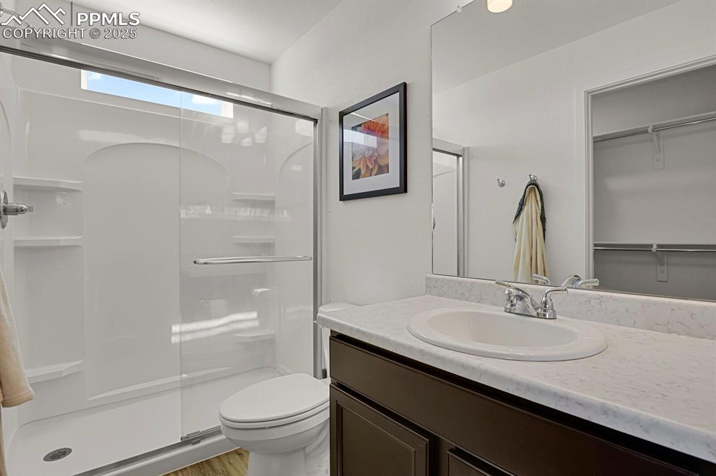 Image 15 of 24: Full bath with vanity, a stall shower, and a spacious closet