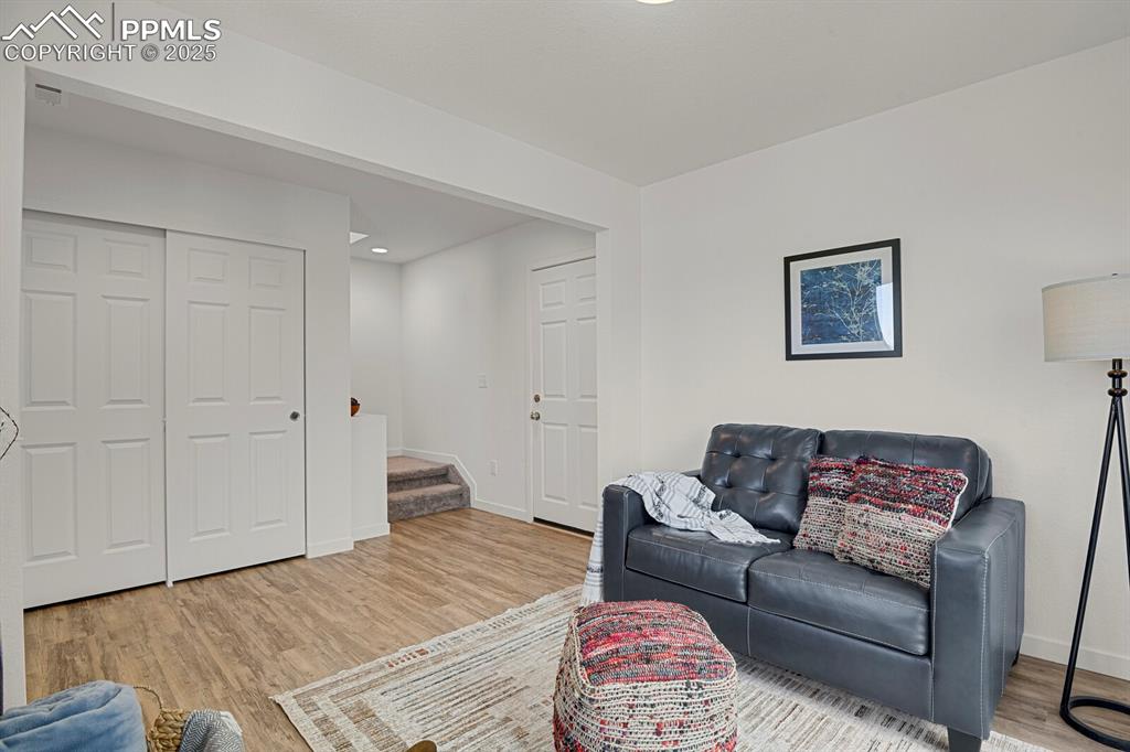Image 17 of 24: Living room with stairway, light wood-style floors, and recessed lighting