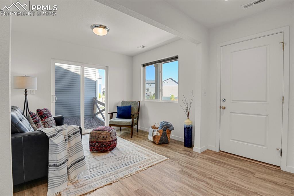 Image 18 of 24: Living area with light wood-style flooring