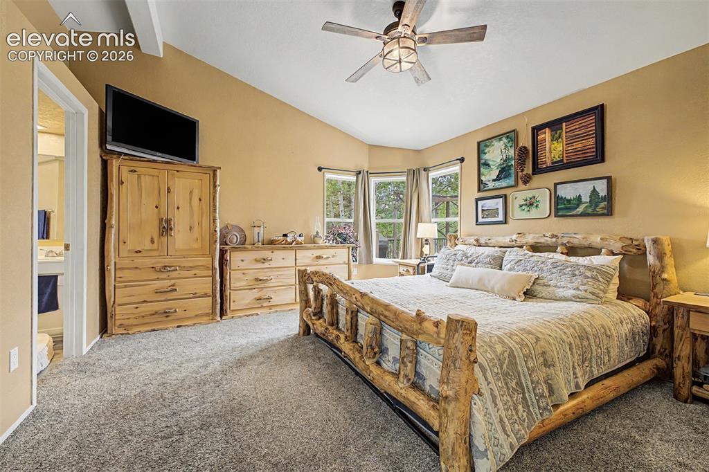 Image 13 of 48: Vaulted ceiling with an exposed beam, ceiling fan, carpet flooring, and mul