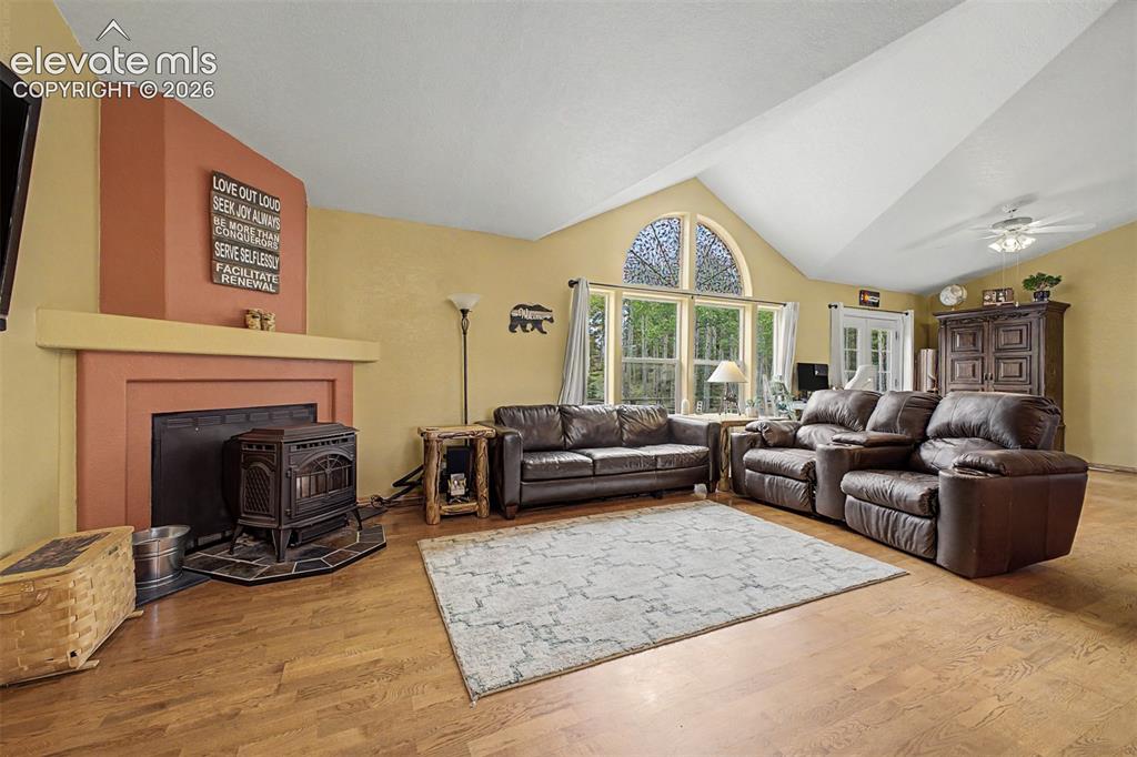 Image 21 of 48: Vaulted ceiling with a ceiling fan, arched window, wood-finish flooring, an