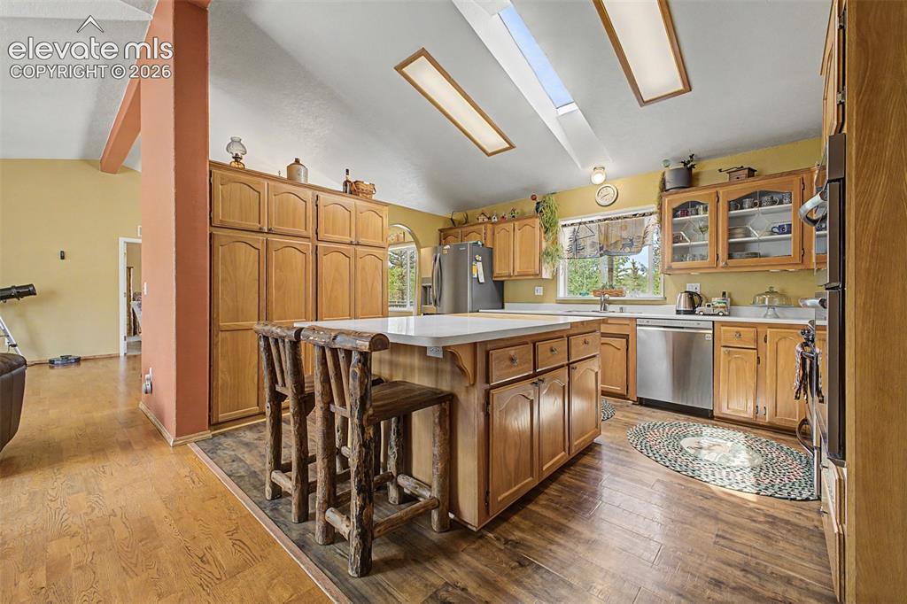 Image 23 of 48: Kitchen featuring wood-finish flooring, natural wood cabinetry, white count