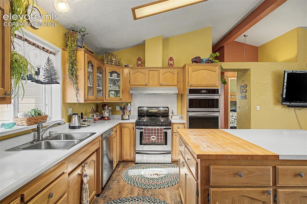 Image 42 of 48: Kitchen featuring light wood cabinetry, white countertops, stainless steel