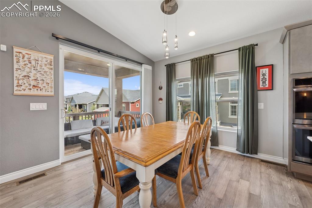 Image 14 of 46: Dining space featuring lofted ceiling, light wood-style floors, and baseboa
