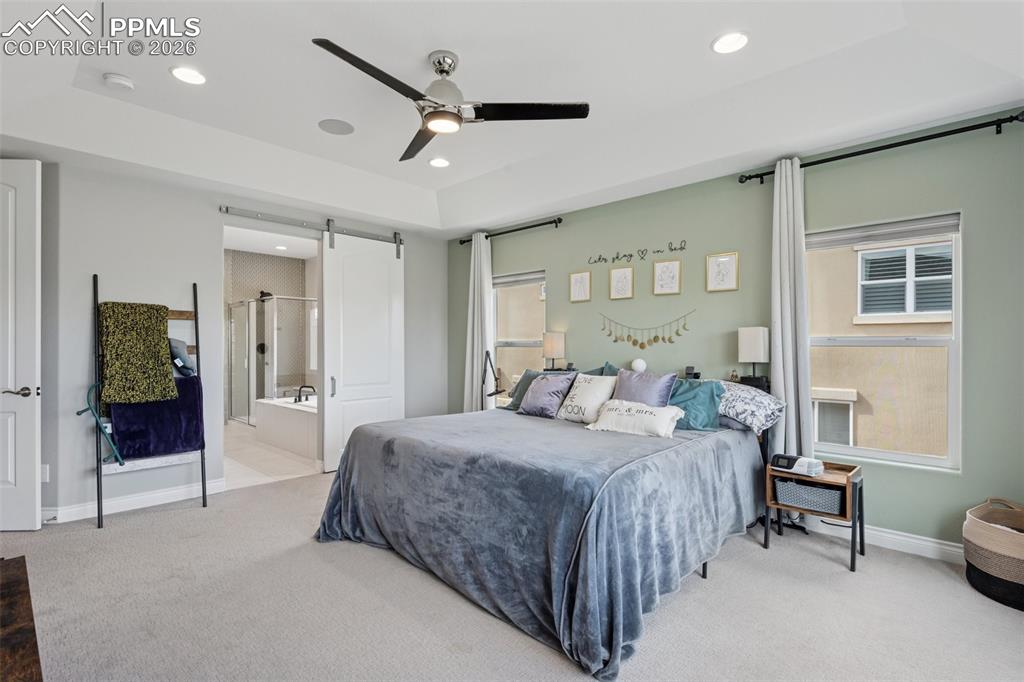 Image 20 of 46: Carpeted bedroom with a barn door, recessed lighting, baseboards, a ceiling