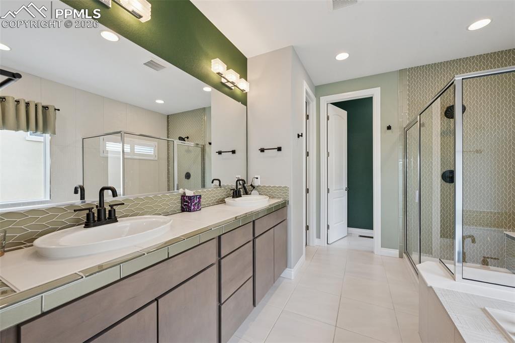 Image 23 of 46: Full bath with a shower stall, tile patterned flooring, double vanity, a tu